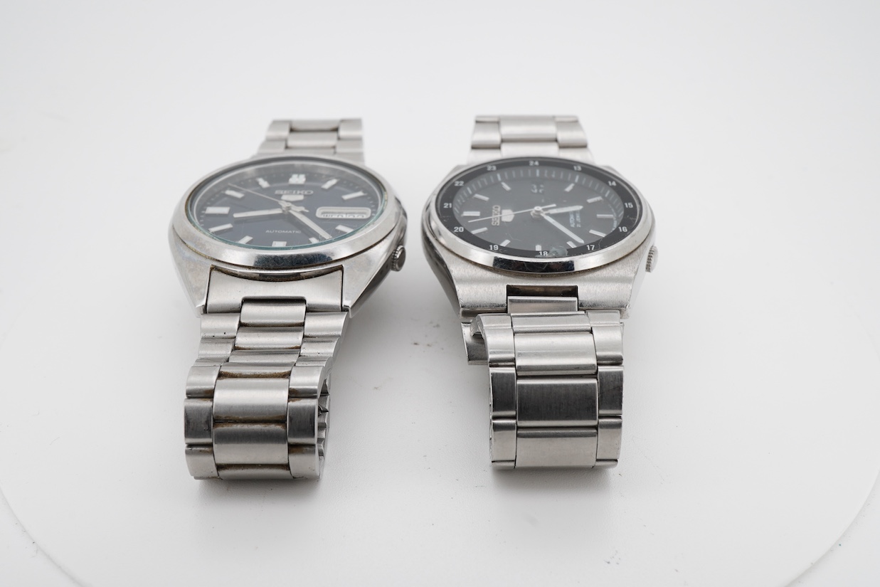Two gentleman's recent stainless steel Seiko 5 automatic day/date wrist watches, one with black dial, the other blue dial, case diameters 36mm, both on stainless steel Seiko straps (one a.f.). no boxes or paperwork.